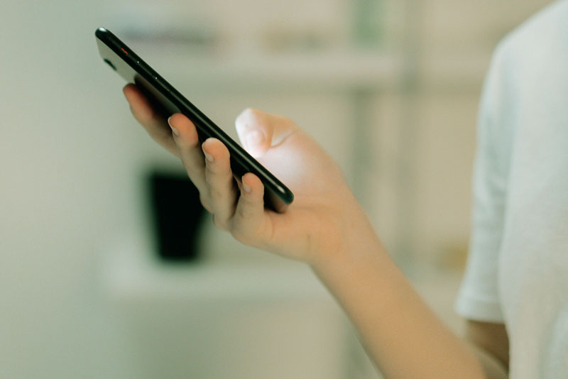 En hand som håller i en mobiltelefon